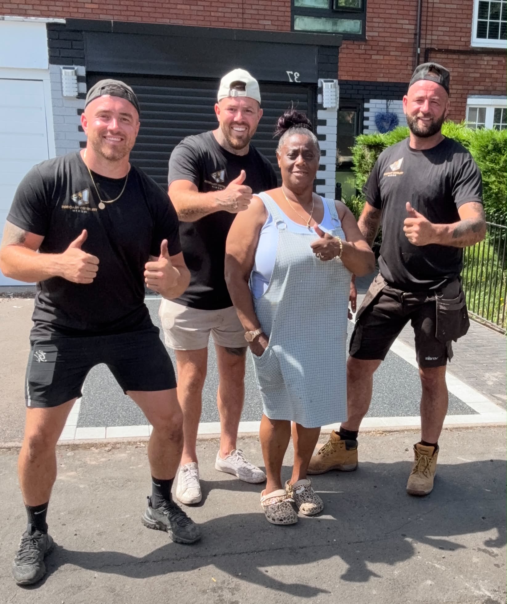 The Trusted Traders Resin team with a happy customer giving thumbs up in front of a finished resin driveway